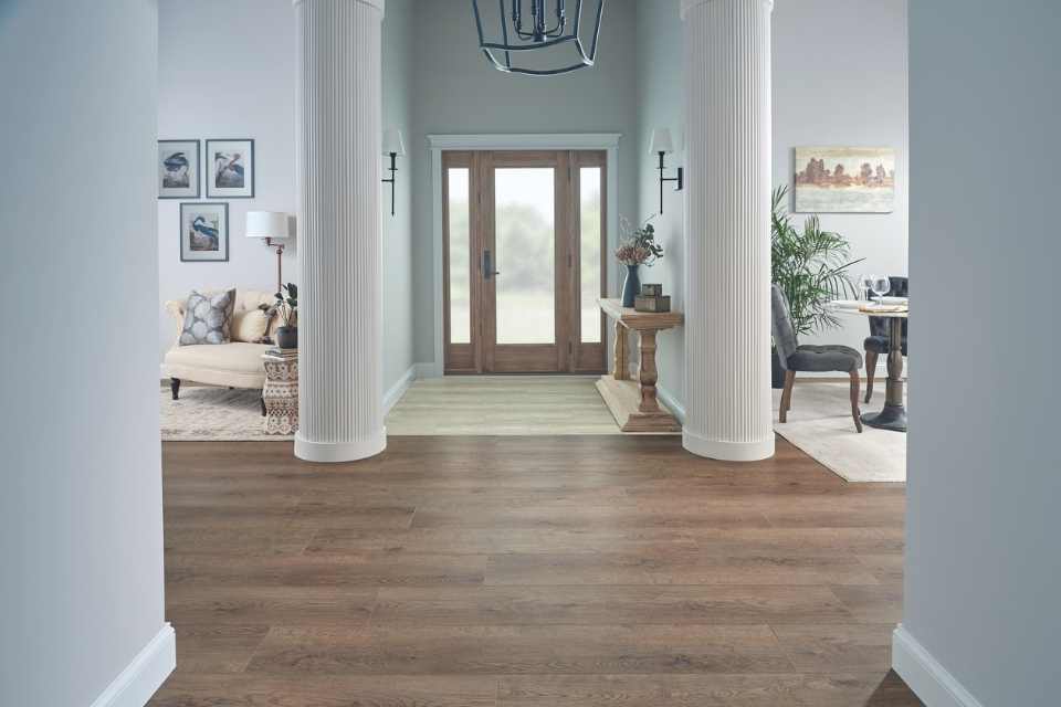 mid range wood-look luxury vinyl in foyer with white columns